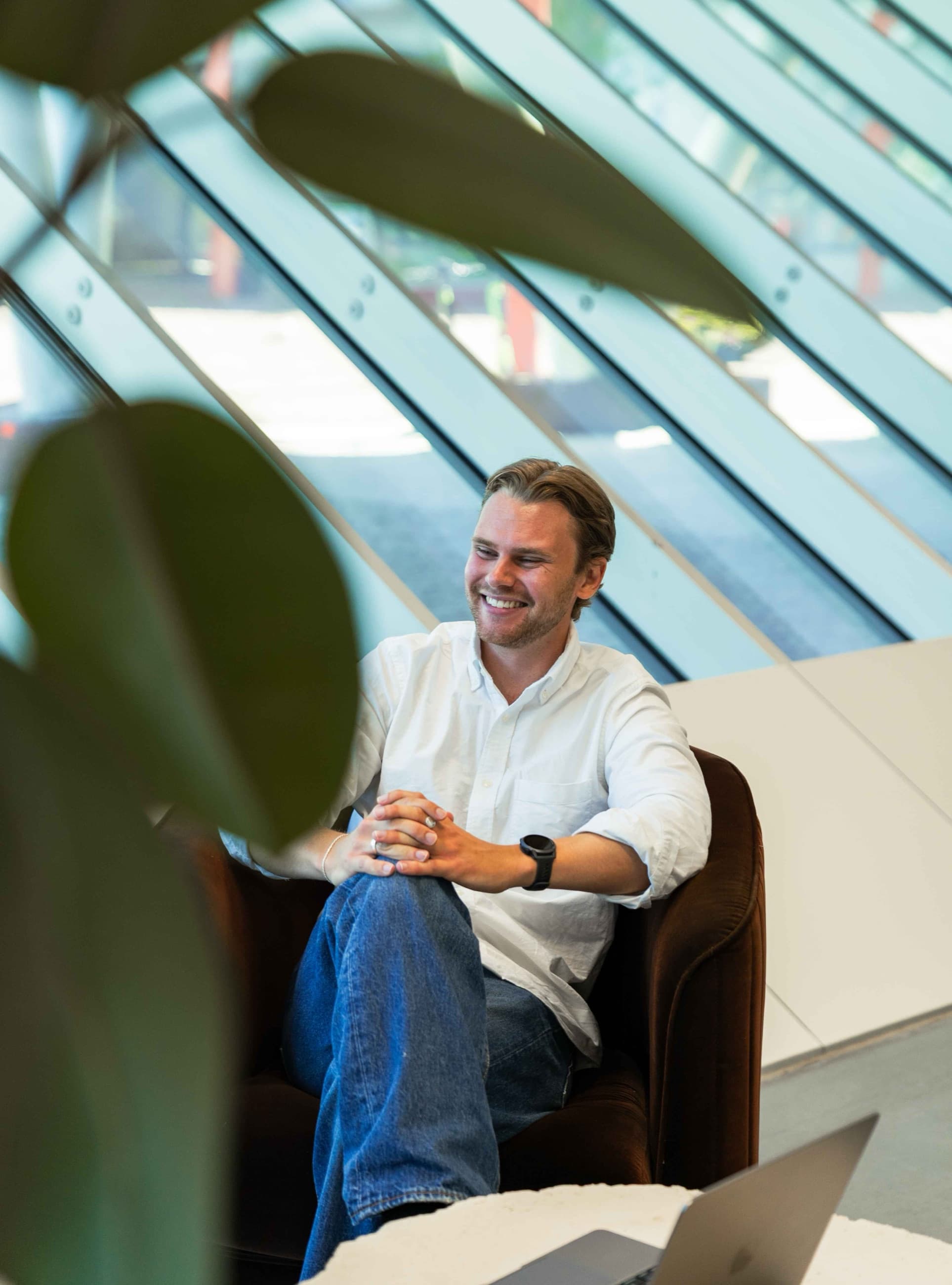 Theo Skogsberg, medgrundare av Mist Creative, sitter avslappnat och ler i en fåtölj i ett ljust rum. Cover till artikel om varför ingen kan garantera en plats i ChatGPT